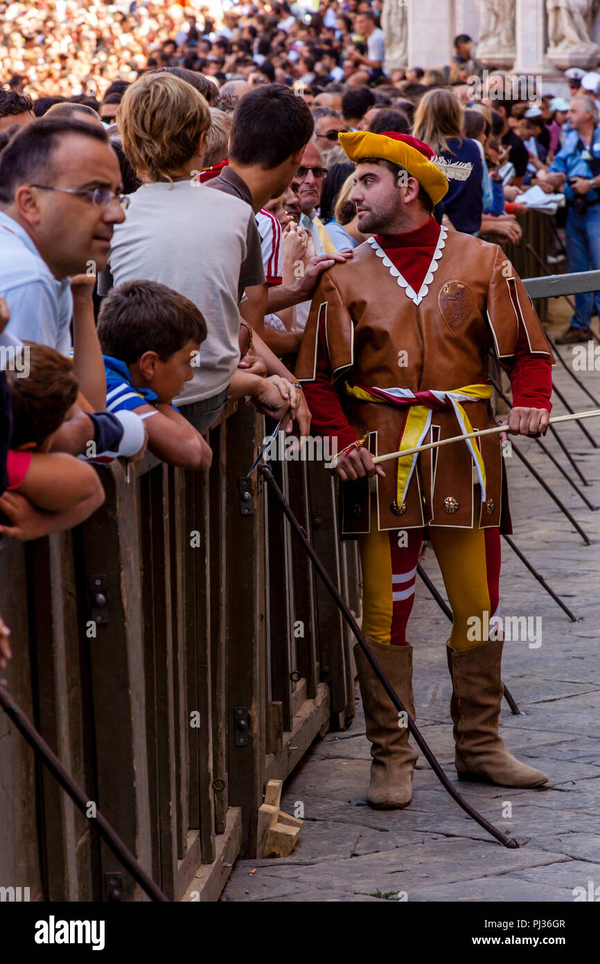 Ein Mann von der Contrada Valdimontone (RAM) wartet auf die Zuordnung der Pferde Zeremonie in der Piazza Del Campo, Palio Di Siena, Italien zu beginnen. Stockfoto