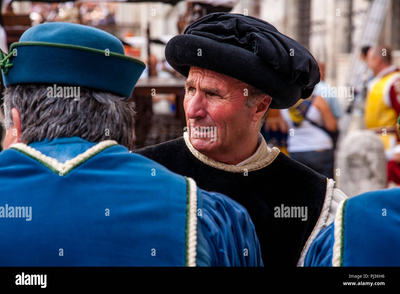 Die Menschen gekleidet in mittelalterlichen Kostüm für die Zuordnung der Pferde Zeremonie in der Piazza Del Campo, Palio di Siena, Siena, Italien beginnen Stockfoto