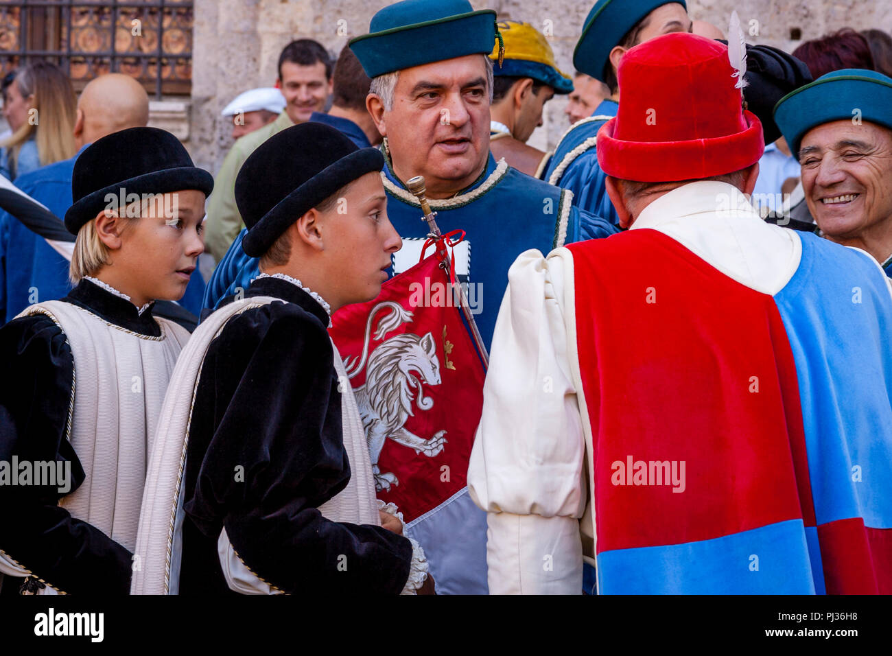 Die Menschen gekleidet in mittelalterlichen Kostüm für die Zuordnung der Pferde Zeremonie in der Piazza Del Campo, Palio di Siena, Siena, Italien beginnen Stockfoto