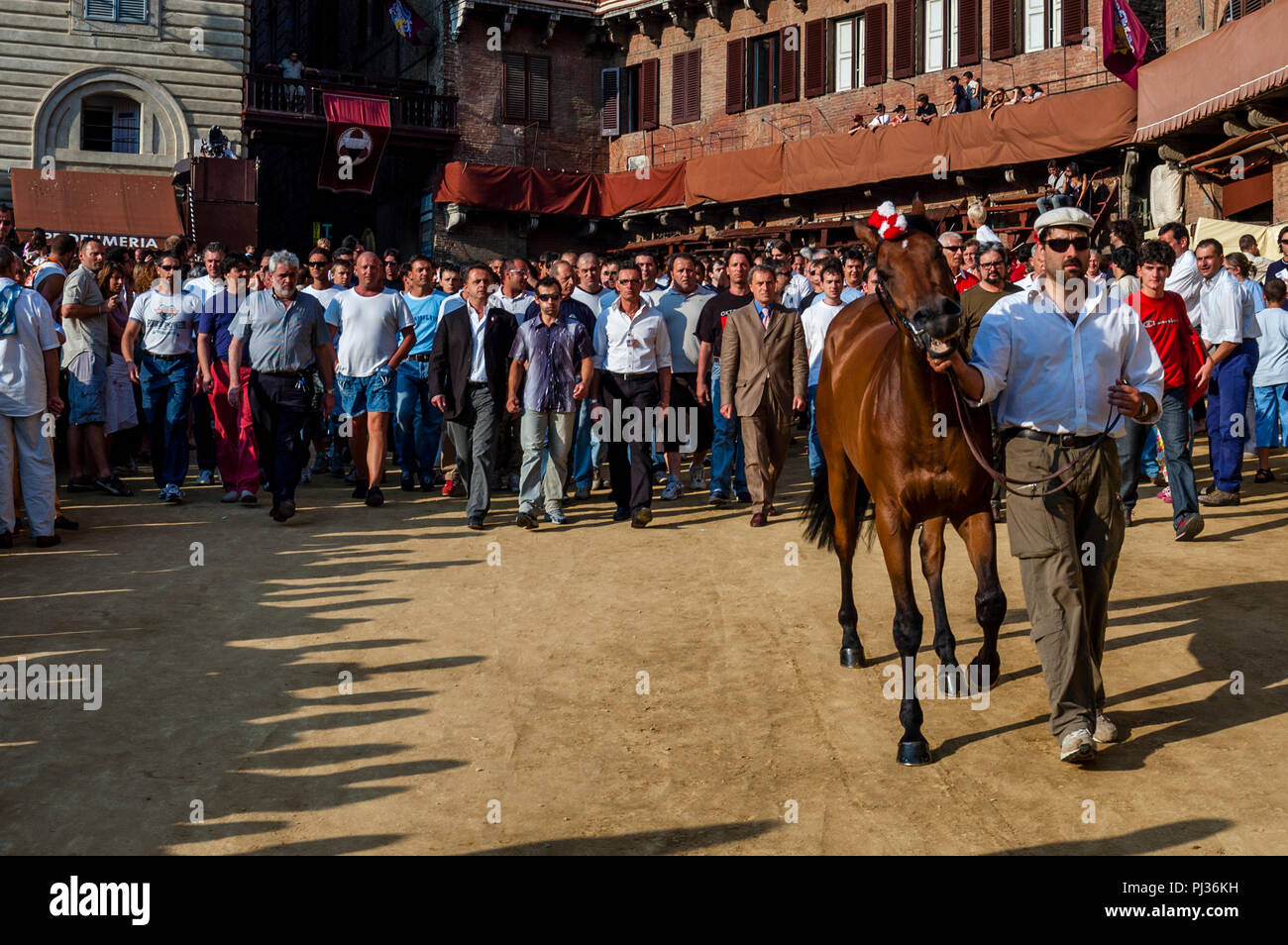 Contrada Mitglieder aus dem Giraffa Contrada kommen in der Piazza Del Campo, einer der sechs Trial Rennen, den Palio di Siena, Siena, Italien Stockfoto