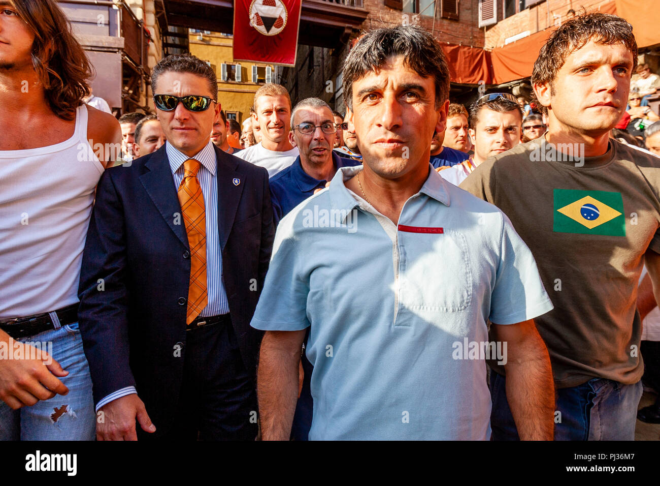 Die berühmten Jockey Giuseppe Pes 'Il Pesse" kommt in der Piazza mit seinem Contrada Escort zu Teil in einer Studie, die Rasse, den Palio Di Siena, Italien Stockfoto