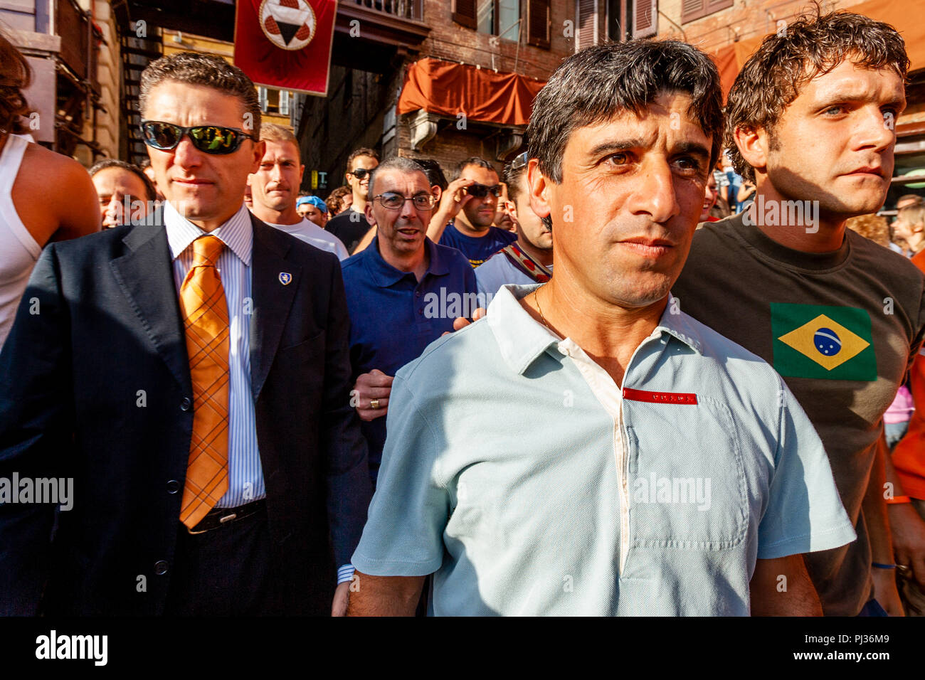 Die berühmten Jockey Giuseppe Pes 'Il Pesse" kommt in der Piazza mit seinem Contrada Escort zu Teil in einer Studie, die Rasse, den Palio Di Siena, Italien Stockfoto