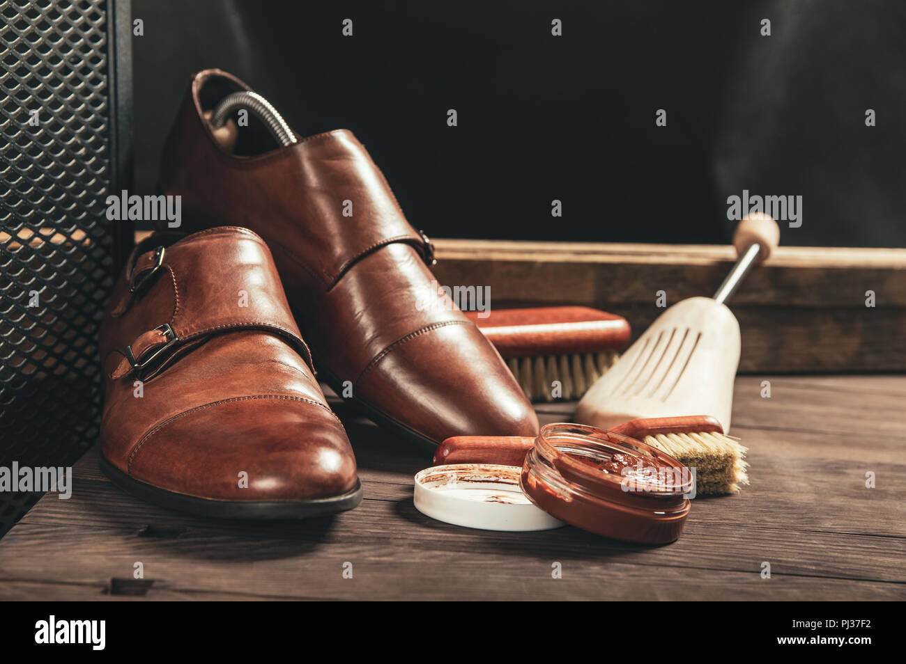 Schuhe aus Leder und Schuhcreme Ausrüstung auf einer hölzernen Zusammensetzung Stockfoto