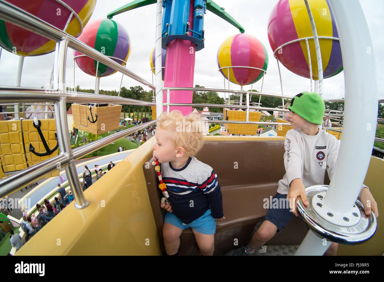 Zwei Jungen im Alter von 2 und 9 Jahren auf großer Ballonfahrt's Solitärspiele, Solitärspiele Welt, Paultons Park, Romsey, Hampshire, England, Vereinigtes Königreich. Stockfoto