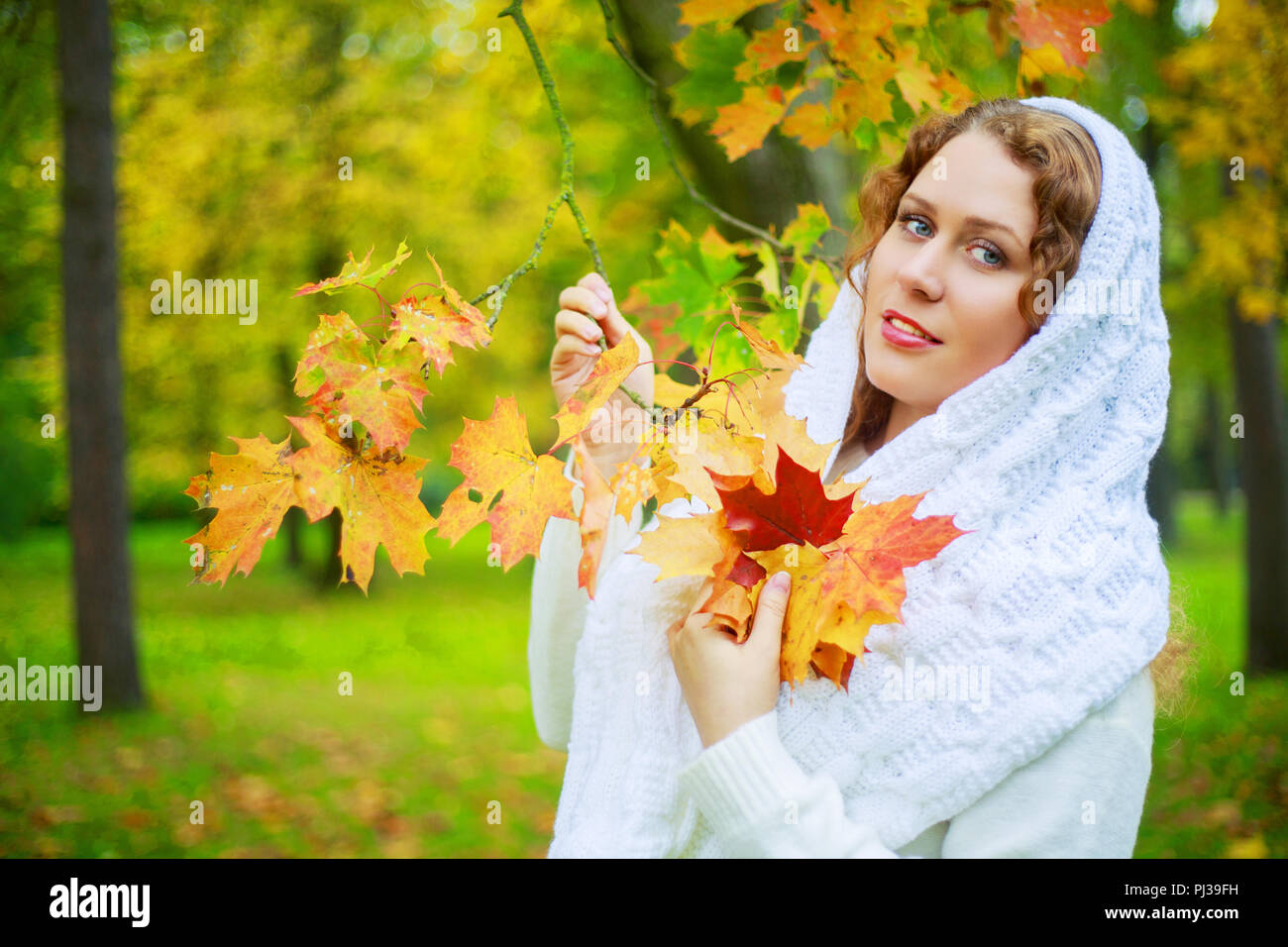 Schöne junge plussize Modell mit langen Locken im Herbst Park Stockfoto