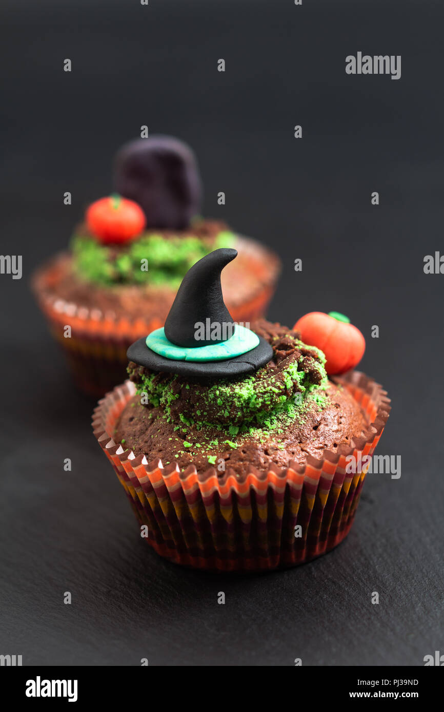 Halloween Urlaub essen bunte Fancy brownies Cupcake mit Hexe und Kürbis fondant Dekorieren Stockfoto
