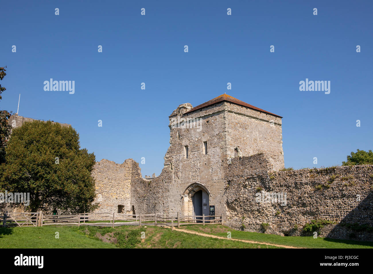Außerhalb des imposanten Mauern von Portchester Castle in der Nähe von Portsmouth in Hampshire. Der blaue Himmel über der mittelalterlichen Festung. Stockfoto