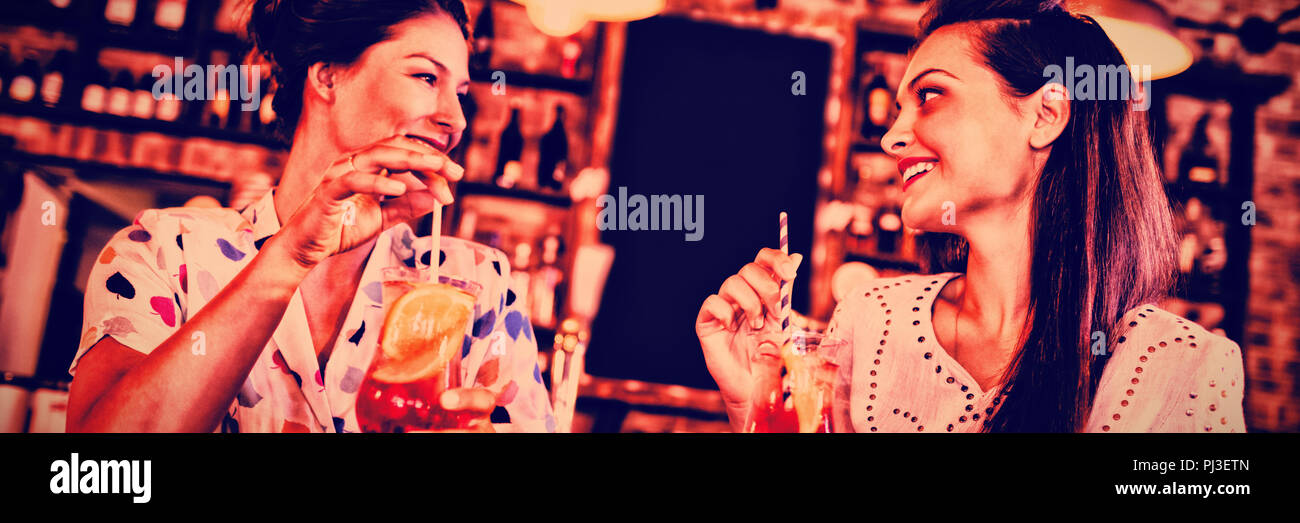 Zwei junge Frauen, die Cocktail Drinks Stockfoto