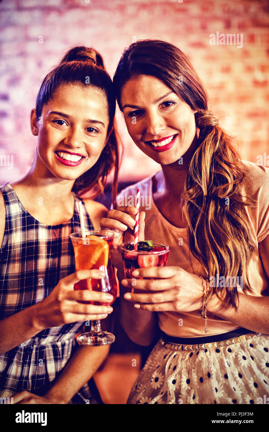 Porträt von zwei jungen Frauen in Cocktail Drinks Stockfoto