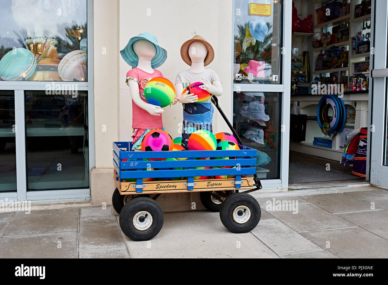 Store Exterieur Anzeige der bunte Kinder Kleidung und Spielzeug auf dem Bürgersteig in Seaside in Florida, USA. Stockfoto