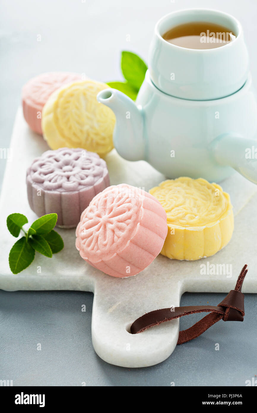 Schnee Haut süße und herzhafte traditionelle Chinesische mooncakes mit verschiedenen Füllungen mit grünem Tee serviert. Stockfoto