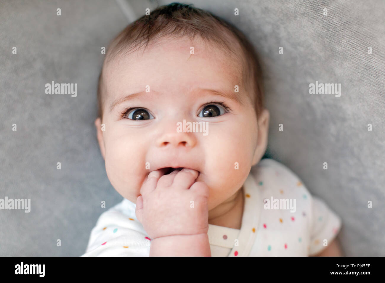 Lustige Baby beißen Finger Stockfoto