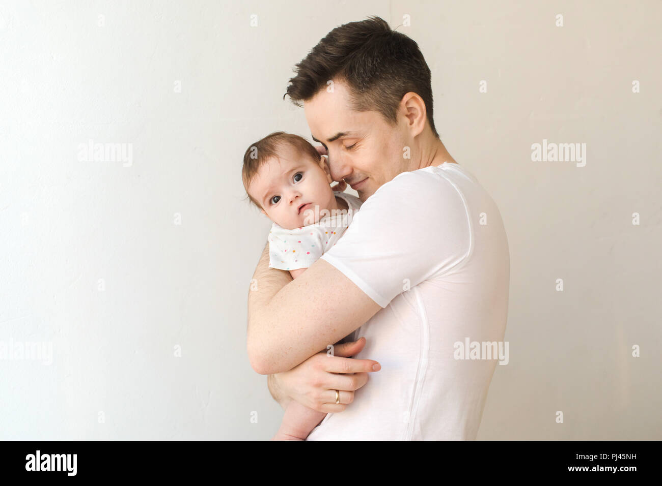 Junger Vater umarmt Baby Stockfoto