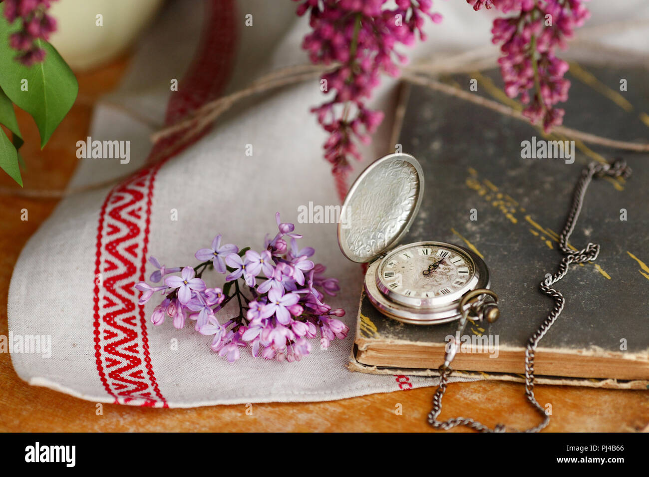 Antike Taschenuhr, Blume vor Holz- Hintergrund Stockfoto