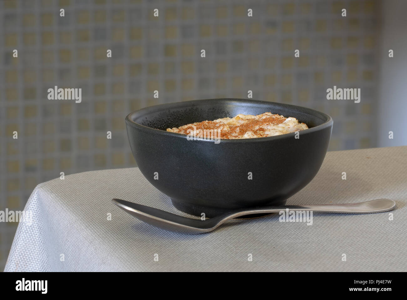 Nur authentische organic Porridge in brauner Schale in der Küche gekocht. Mit Zimt und Löffel. Ganze Korn Hafer. Stockfoto