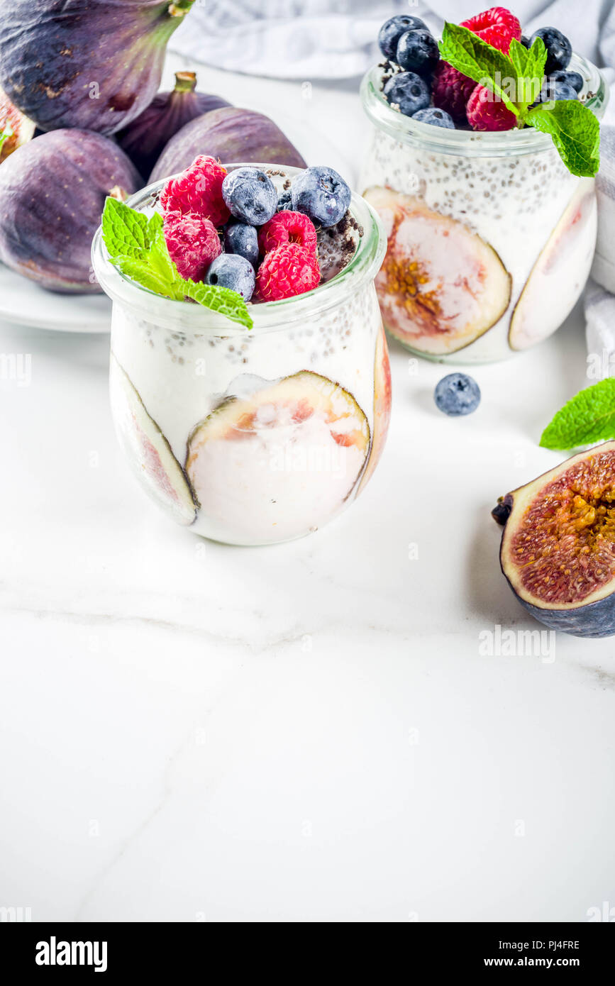 Gesunde detox Frühstück Vorspeise - Joghurt Smoothie oder Milchshake mit Feigen, Blaubeeren, Himbeeren Chia Samen, weißem Marmor Hintergrund Kopie Raum Stockfoto