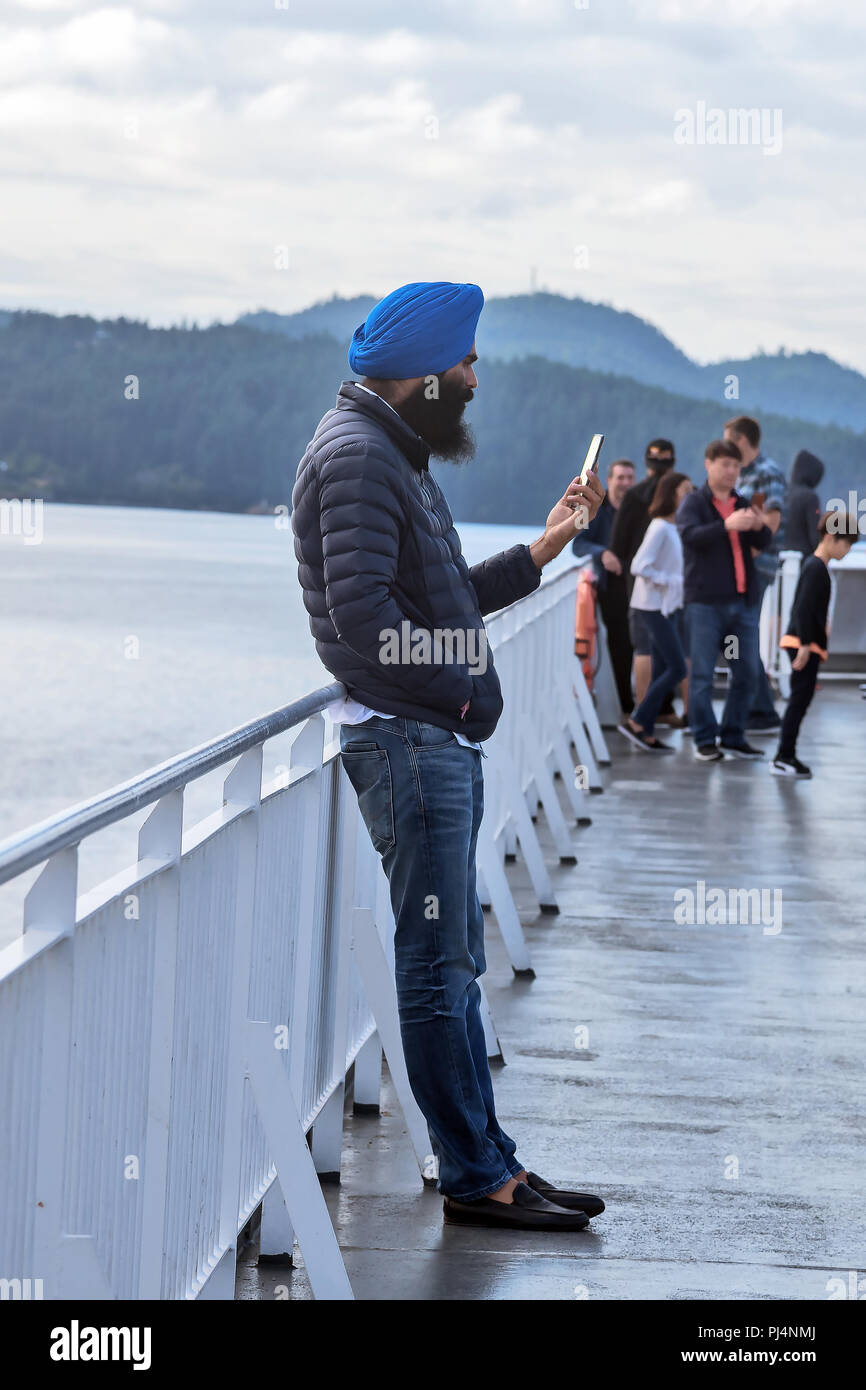 Passagier in chalm mit Telefon auf dem Deck, Fähre, Vancouver, Victoria, Kanada Stockfoto