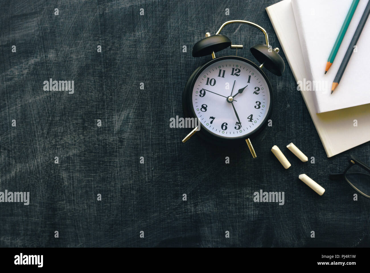 Es ist Zeit, Ansicht von oben flach vintage Wecker, Kreide und Bücher über blackboard Oberfläche als Kopie Raum Stockfoto