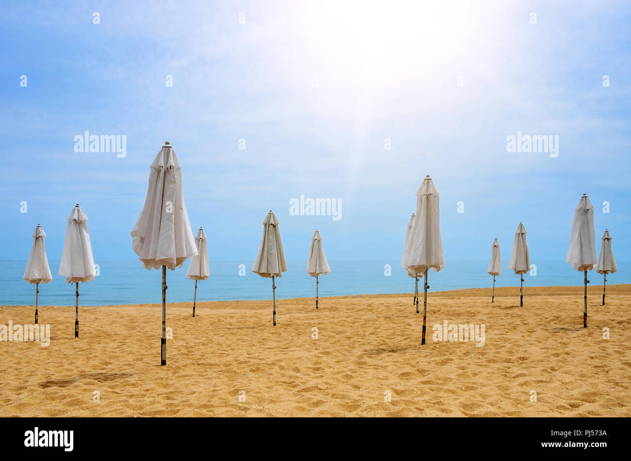 Geschlossenen Sonnenschirmen an einem einsamen Strand. Close-up. Stockfoto