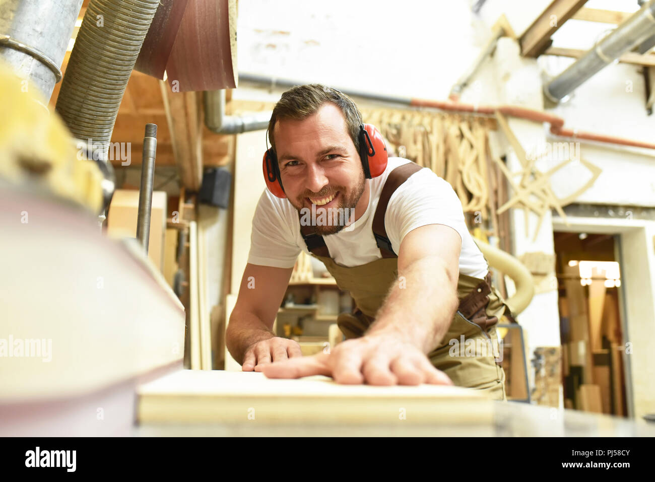 Tischler arbeitet in einer Tischlerei - Workshop für die Holzbearbeitung und Sägen Stockfoto