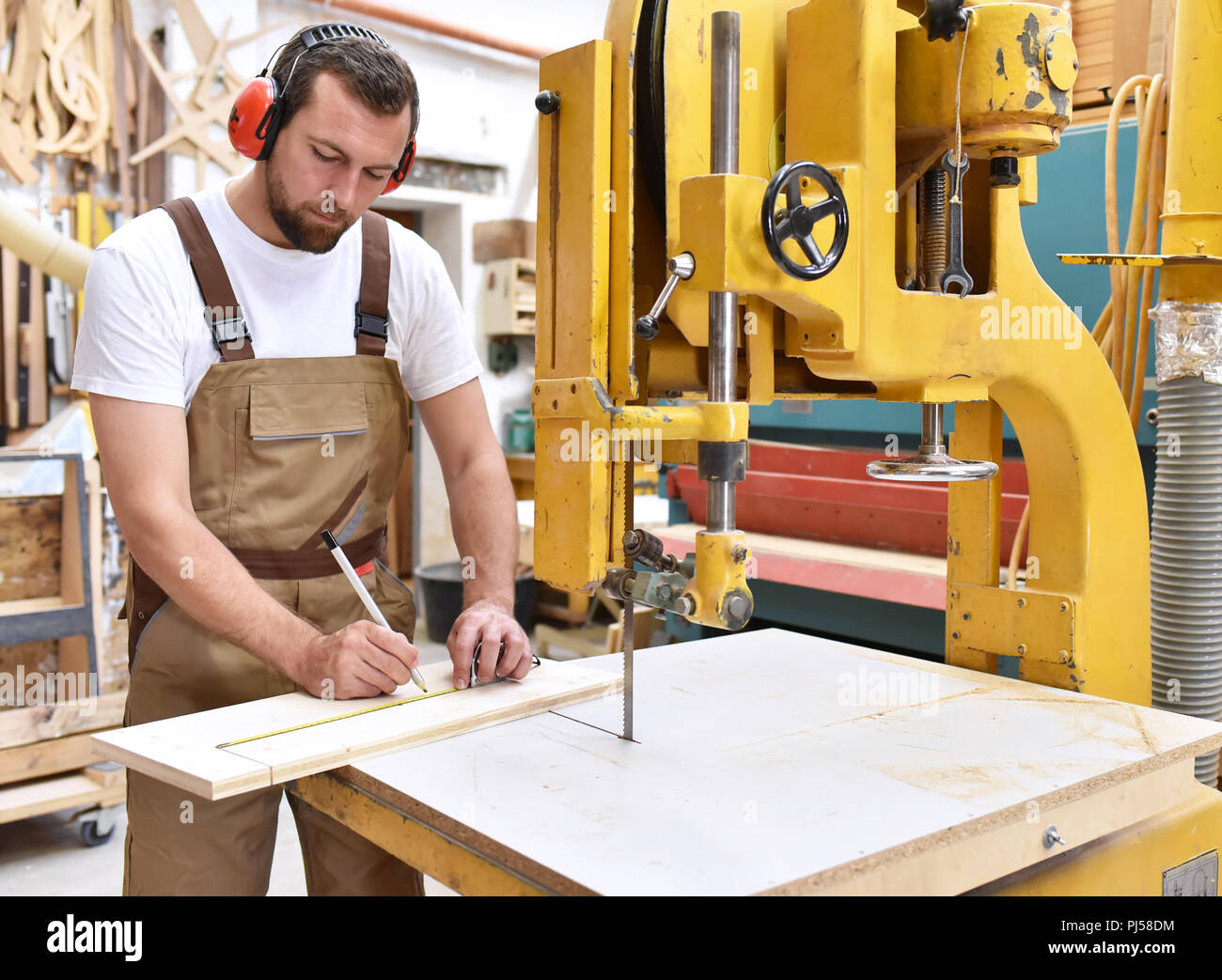 Tischler arbeitet in einer Tischlerei - Workshop für die Holzbearbeitung und Sägen Stockfoto