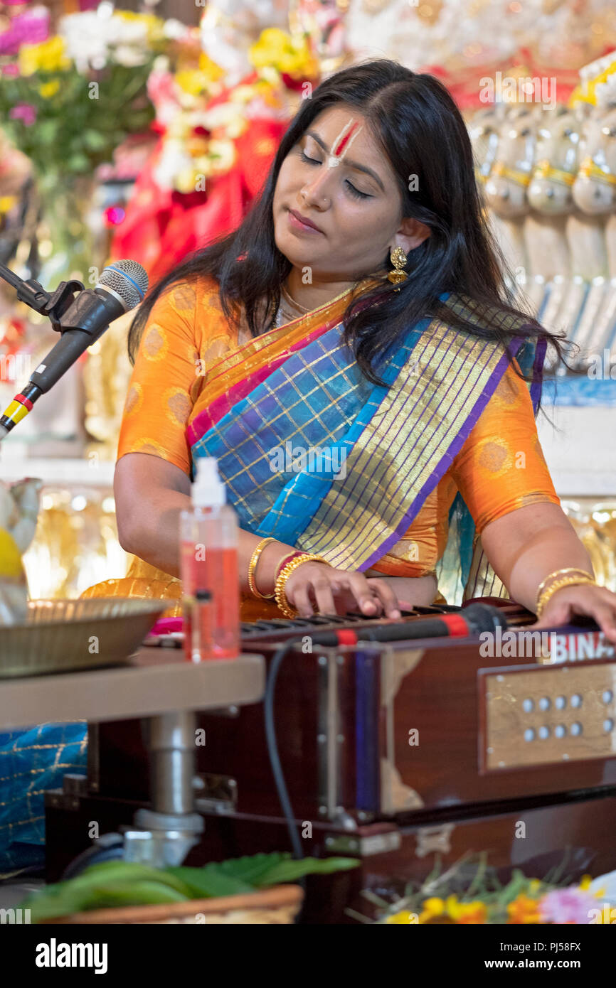 Eine Frau Priester führenden ein Hindu Janamashtmi Service feiert die Geburt der Gottheit Krishna. In Queens, New York. Stockfoto