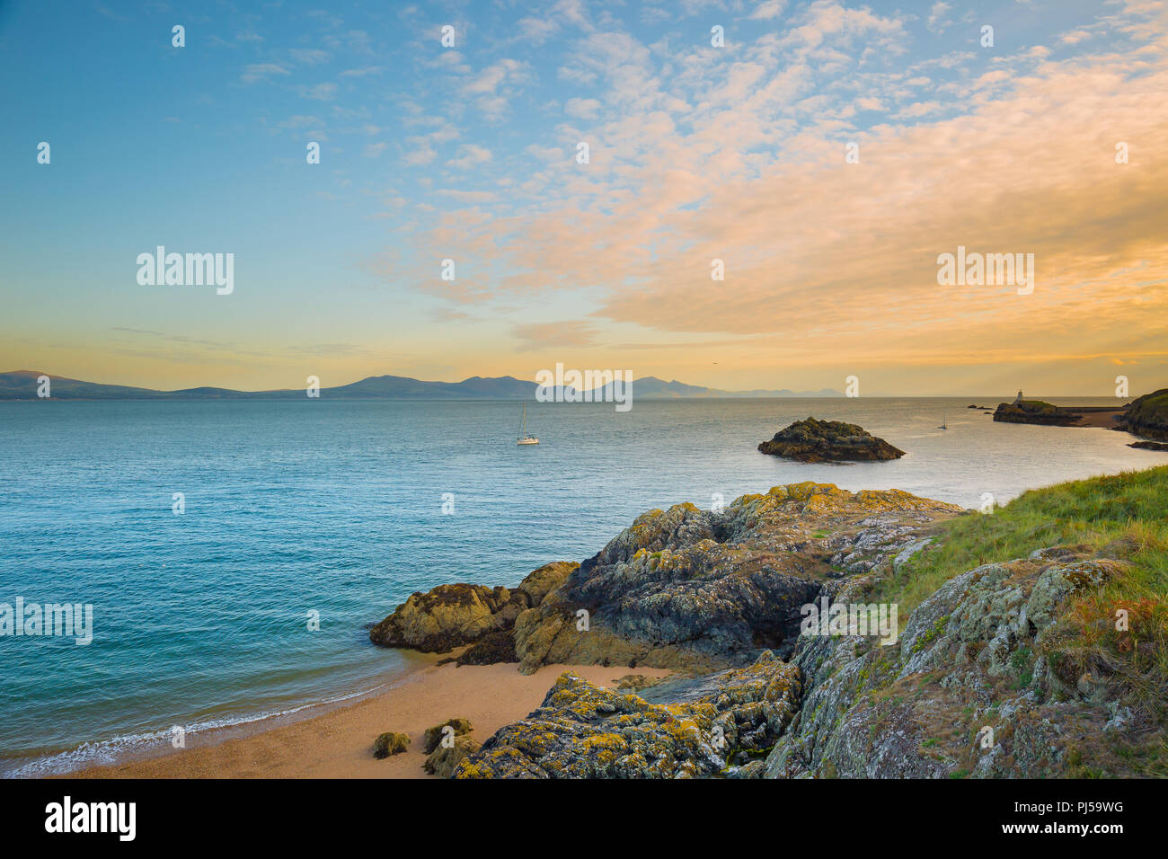 Arty, Sonnenuntergang seascape Blick vom Felsen auf Ynys Llanddwyn (Tidal Insel Anglesey N. Wales) in Richtung Yr Eifl (Die Rivalen in Englisch). Erstaunlich sky Stockfoto