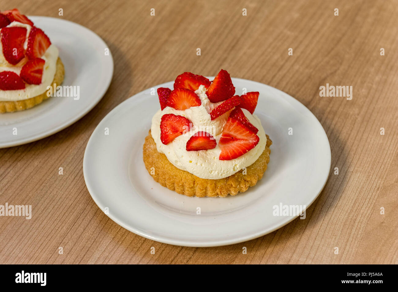 Erdbeeren mit Sahne auf Shortbread Keks auf weiße Platte Stockfoto