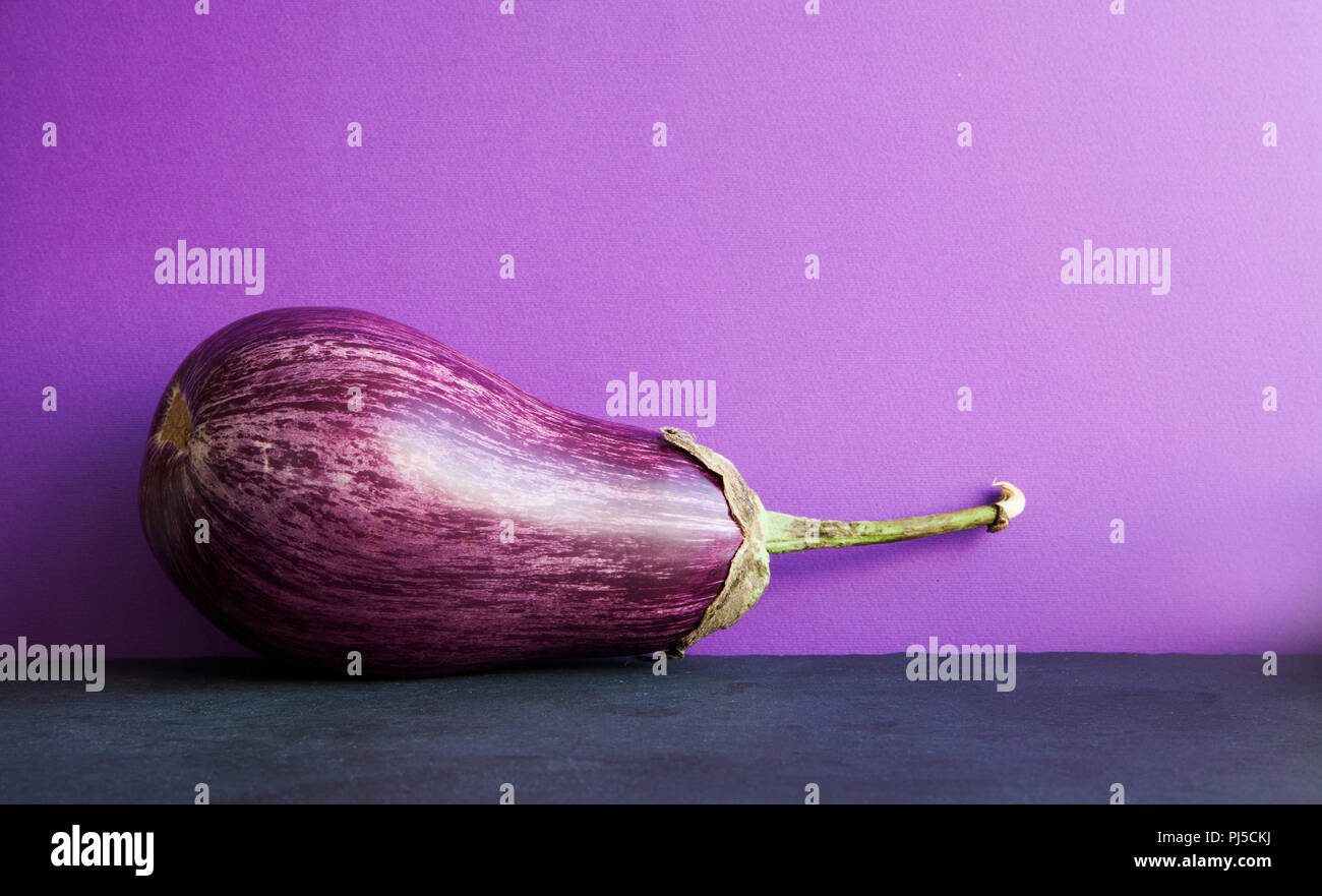 Violett Aubergine auf violett schwarz hintergrund Reif. Bio Gemüse mit schönen Streifenmuster. Platz kopieren Stockfoto