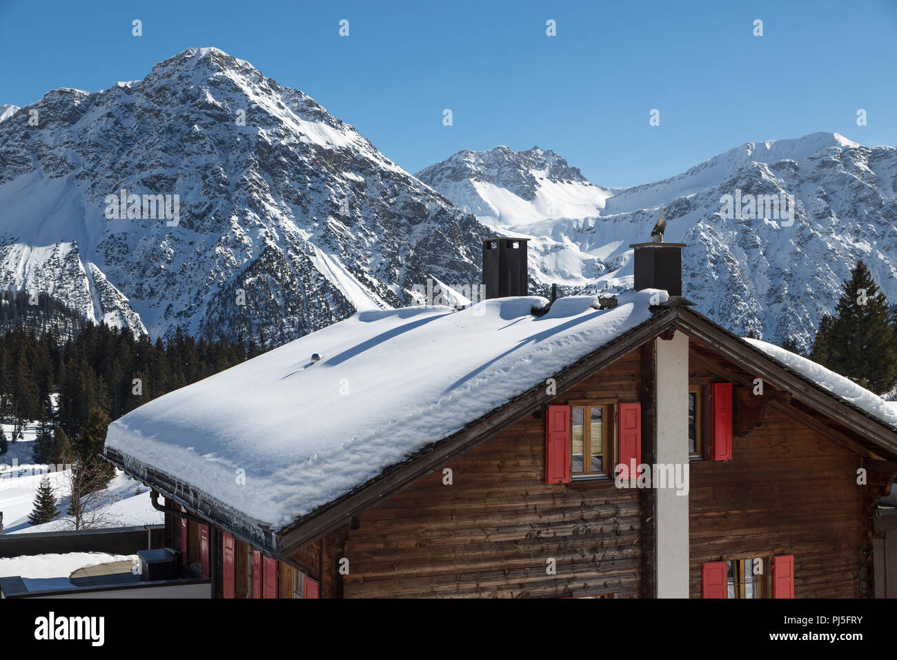 Woodhouse mit schneebedeckten Dach in Arosa Stockfoto