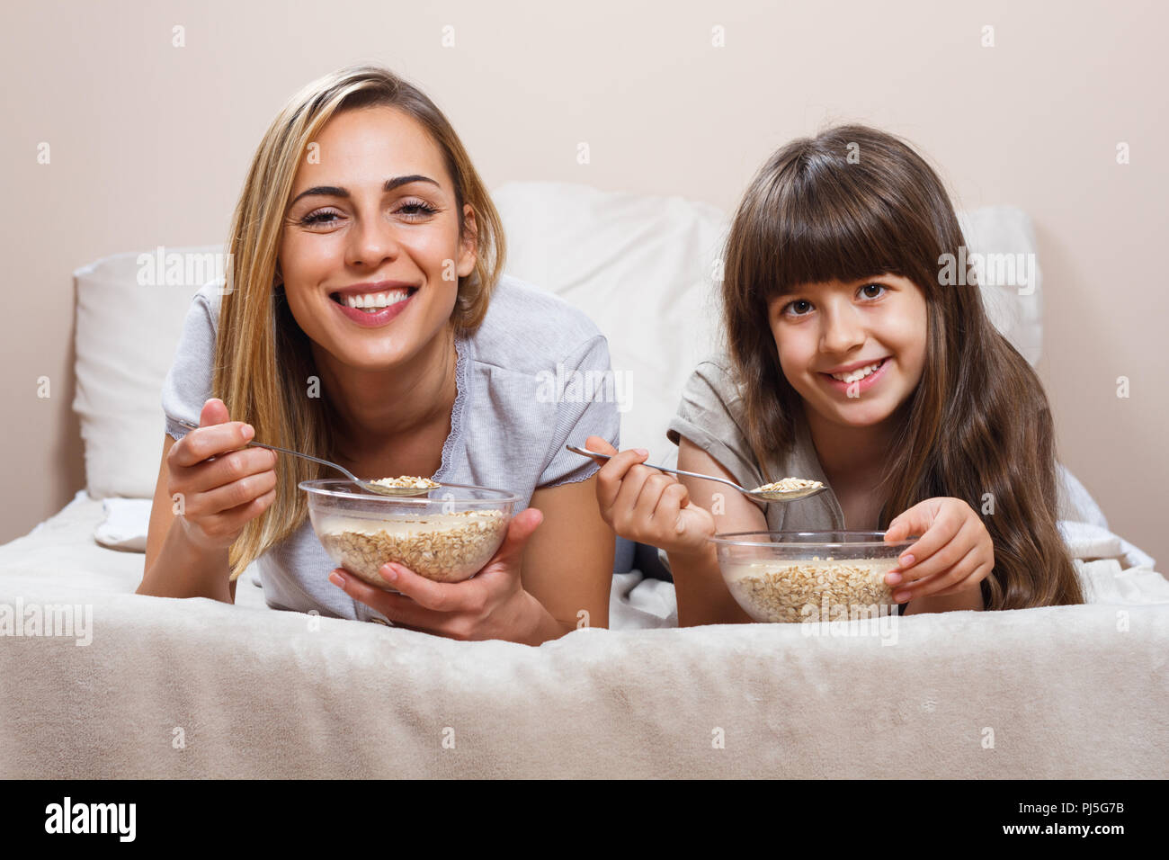 Gesundes Frühstück im Bett für Mutter und Tochter Stockfoto