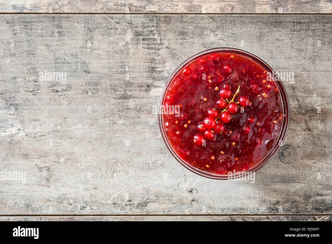Cranberry Sauce in der Schüssel für Thanksgiving Abendessen am Holztisch. Ansicht von oben. Copyspace Stockfoto