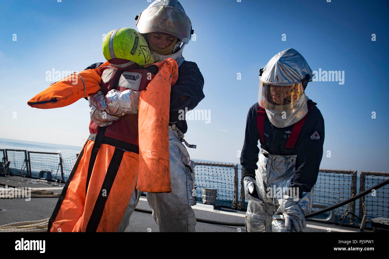 Die USS Carney (DDG 64) ist ein Lenkraketenzerstörer der Arleigh-Burke-Klasse, der im Jahr 2018 Notfallübungen im Flugzeugdeck durchführt, bei denen es um die Evakuierung von Unfallopfern während der Feuerwehrübungen im Schwarzen Meer ging. Das Archivbild zeichnet koordinierte Schadensbegrenzungsmaßnahmen auf, die für die Krisenreaktion an Bord und den Schutz der Besatzung erforderlich sind. Stockfoto