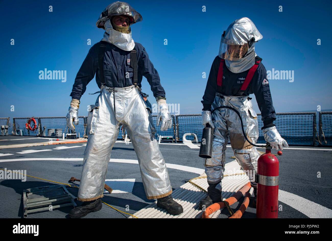 Die USS Carney (DDG 64) ist ein Lenkraketenzerstörer der Arleigh-Burke-Klasse, der während 2018 Seefahrten Flugzeugfeuerbekämpfung und Evakuierungsübungen auf seinem Flugdeck im Schwarzen Meer durchführt. Das Archivbild dokumentiert koordinierte Notfallmaßnahmen, die die Standards für die Sicherheit und Bereitschaft der Marine unterstützen. Stockfoto