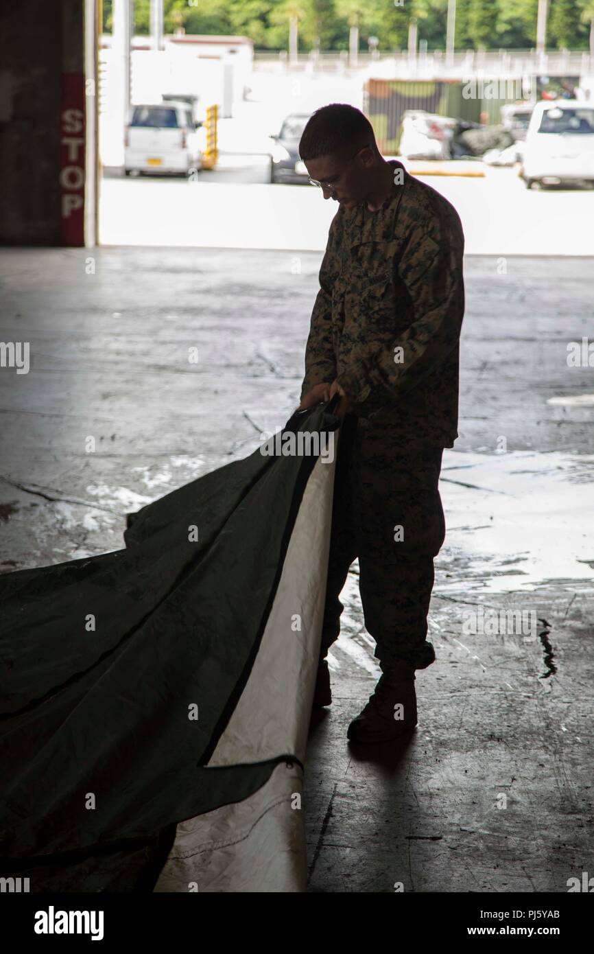 Cpl. Alexander Grasso, ein Data Systems Specialist mit Communications Company, Headquarter Regiment, 3. Marine Logistik Gruppe, flacht ein Zelt vor dem Einklappen es nach III Marine Expeditionary Force Command Post Übung 18.1 (MEF CPX 18.1) Aug 30, 2018 bei militärischen Hafen Naha, Okinawa, Japan. HQ-Reg. Marines wurden mit dem Set-up, Sicherheit beauftragt und Außerbetriebnahme des operationellen Platz für MEF CPX 18.1. Grasso ist ein Eingeborener von Fall River, Massachusetts. (U.S. Marine Corps Foto von Lance Cpl. Jamin M. Powell) Stockfoto