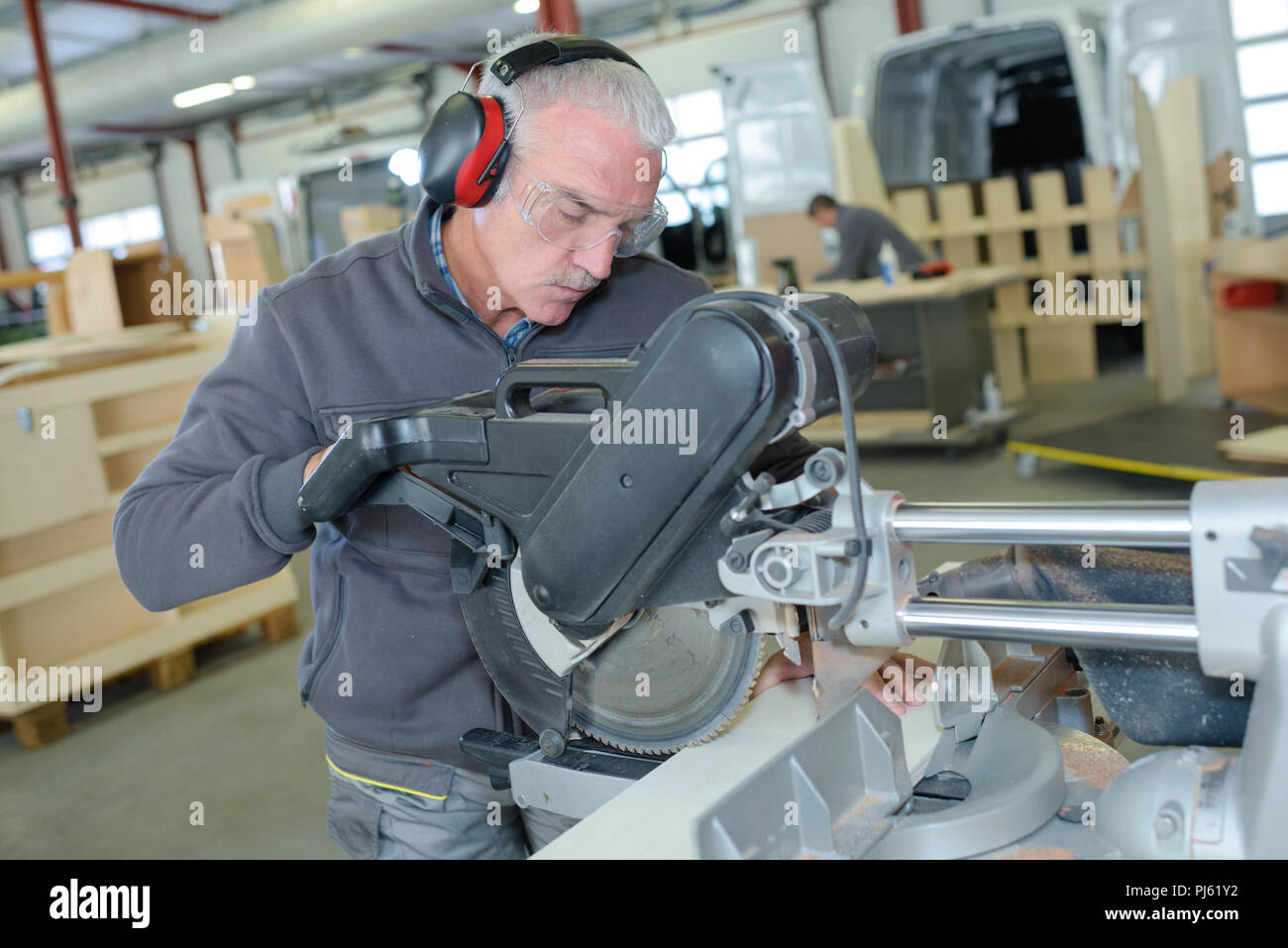 Bauarbeiter über Schieber compound Mitre saw oder Kreissäge Stockfoto