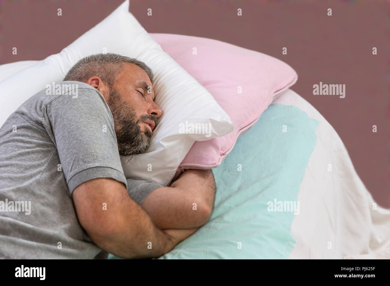 Glücklich zu schlafen. Junger Mann schlafen auf seinem Bett mit geschlossenen Augen Stockfoto