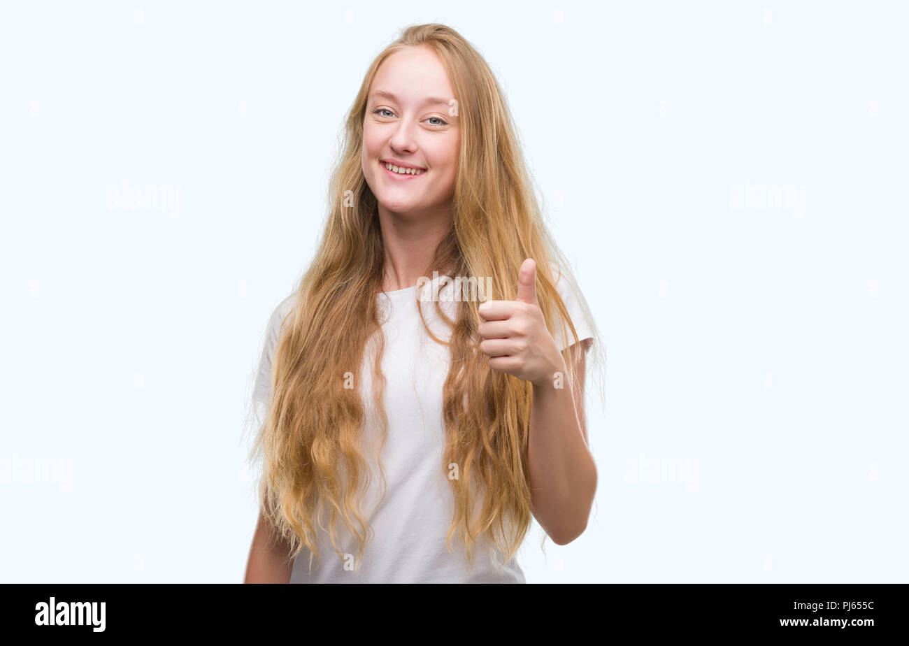 Blonde Teenager Frau mit grossen Lächeln tun ok Zeichen, Daumen hoch, mit den Fingern glücklich, ausgezeichnete Zeichen Stockfoto