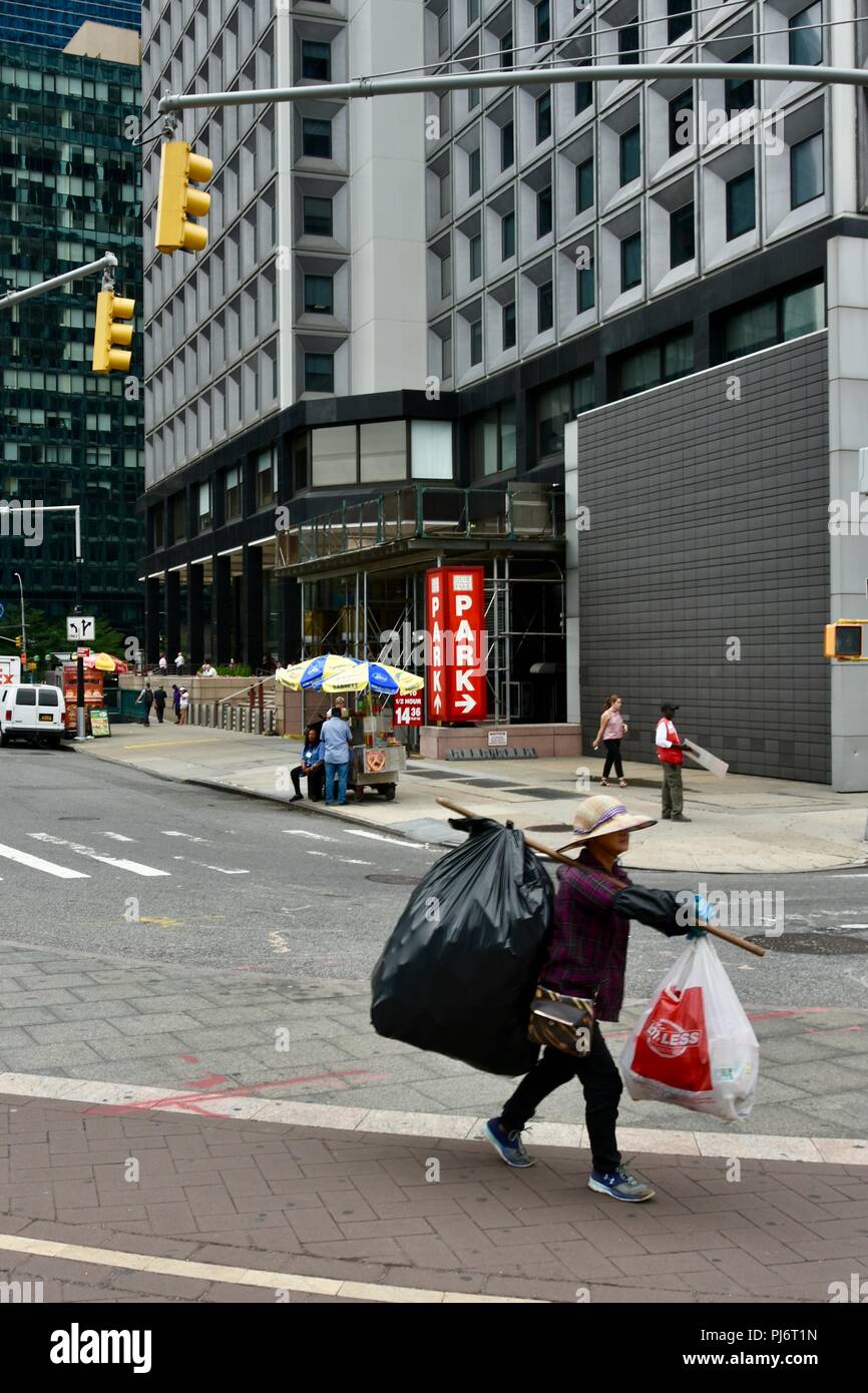 Eine asiatische Frau, die Taschen voll von Dosen und Flaschen, die in New  York. Diese haben von Mülltonnen für den Verkauf auf und Recycling  getroffen worden Stockfotografie - Alamy