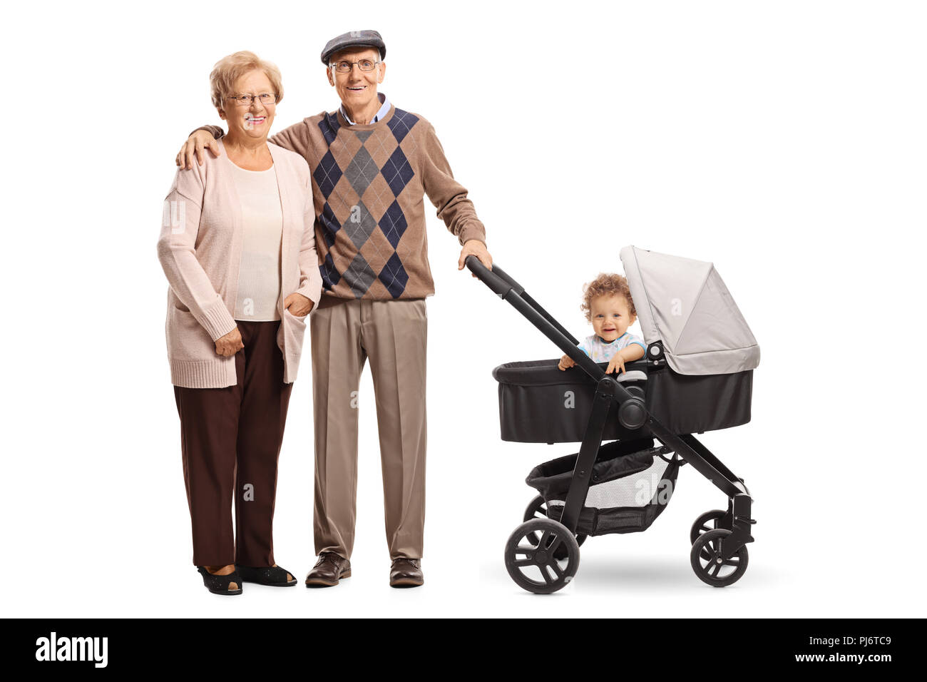 Glückliche Großeltern stehen mit dem Kinderwagen und ihren Enkel auf weißem Hintergrund Stockfoto