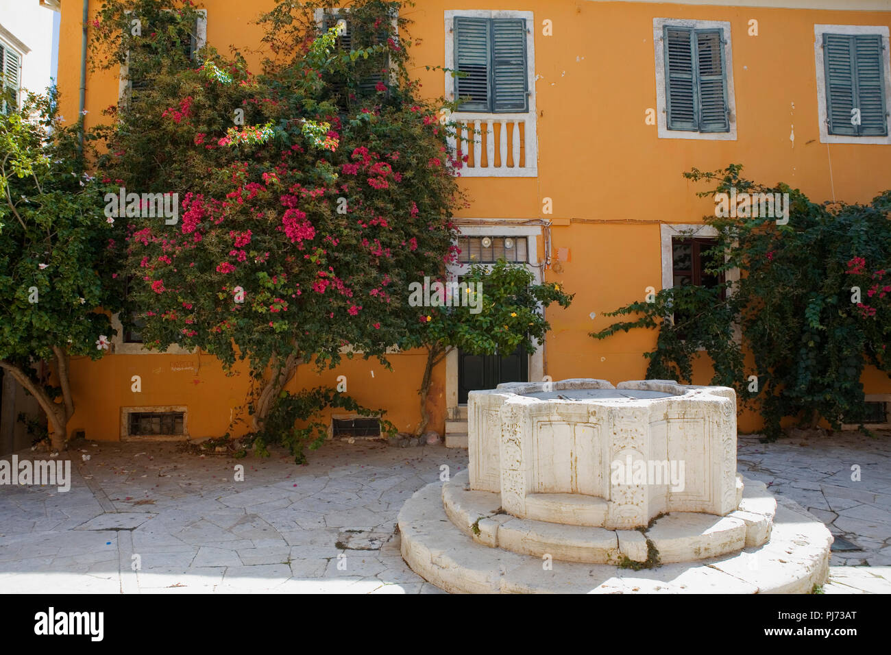 Kremasti Square, aka Parados Komninon mit einem venezianischen Brunnen in der Mitte, Campiello, Korfu, Griechenland Stockfoto