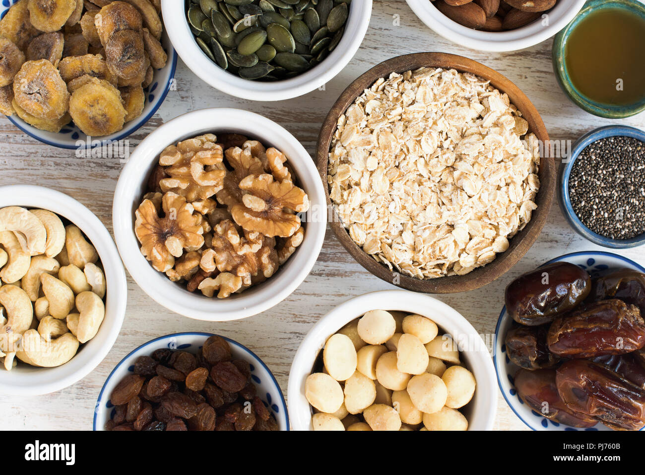 Hausgemachtes Müsli Müsli Zutaten, Hafer, Walnüsse, Mandeln, Cashews, Kürbiskerne, Rosinen, Bananen, Datteln, Honig, Ansicht von oben Stockfoto