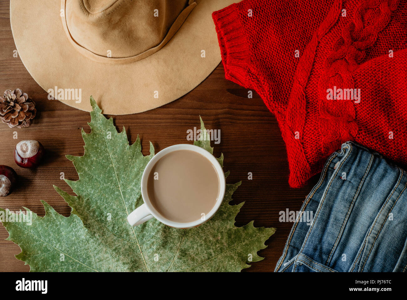 Flach der Herbst Herbst warme Kleidung Tasse Kaffee und Herbst Blatt über Holz- Hintergrund. Herbst Herbst gemütliche Konzept Stockfoto