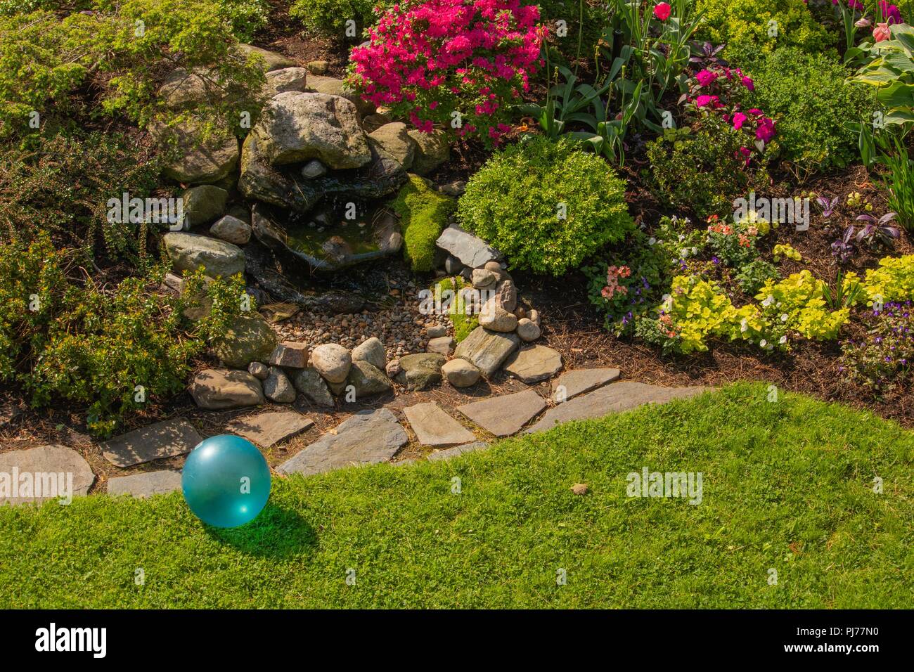 Garten im Hinterhof Brunnen Design mit hellen Türkisblau Kindheit Spielzeug Ball im Frühjahr Sonnenlicht Stockfoto