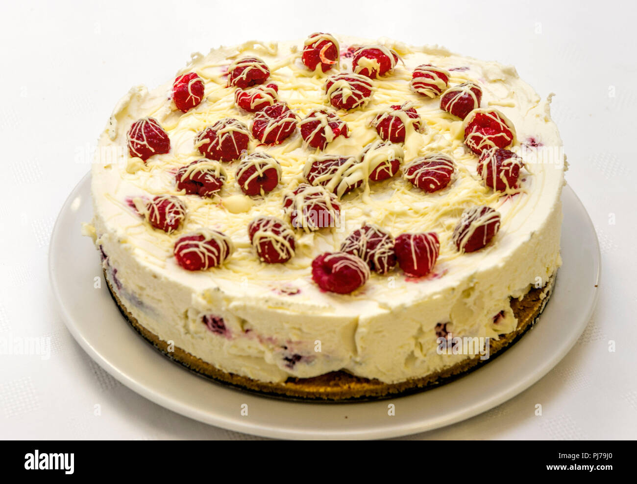 Hausgemachte raspberry Cheesecake garniert mit frischen Himbeeren und Sahne Stockfoto