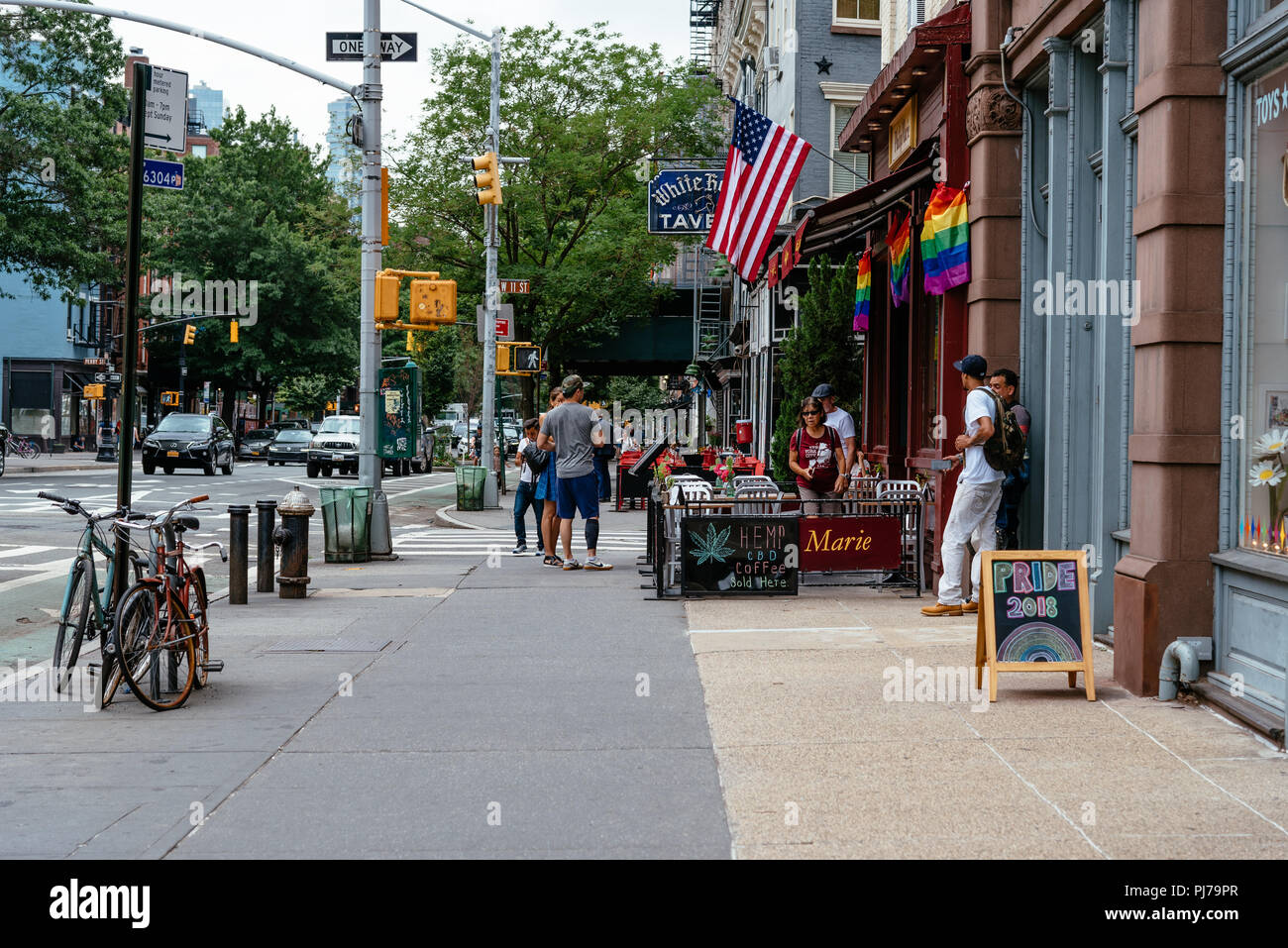 New York City, USA - 22. Juni 2018: Sidewalk Cafe mit Gay Pride Regenbogen Flaggen in Greenwich Village eingerichtet Stockfoto