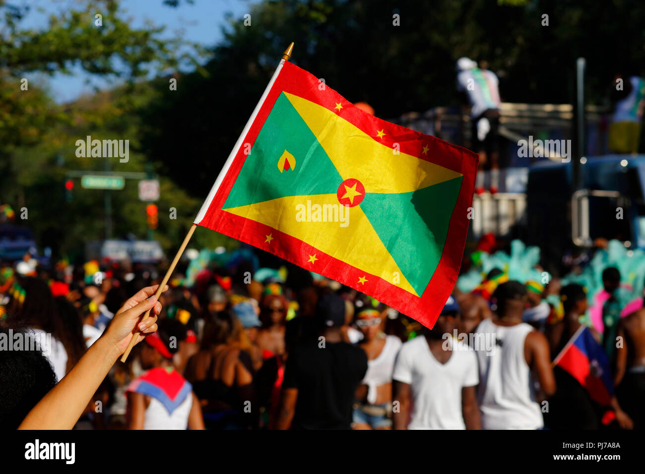 Eine Person, die Wellen eine Flagge Grenada an der West Indian Day Parade in Brooklyn Stockfoto