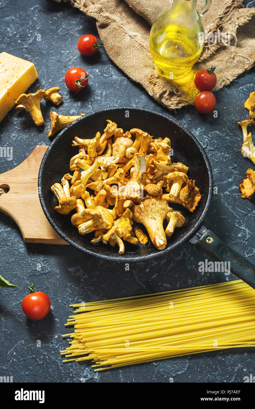 Teigwaren und Pfifferlingen Pilz auf dunklem Stein Hintergrund Stockfoto