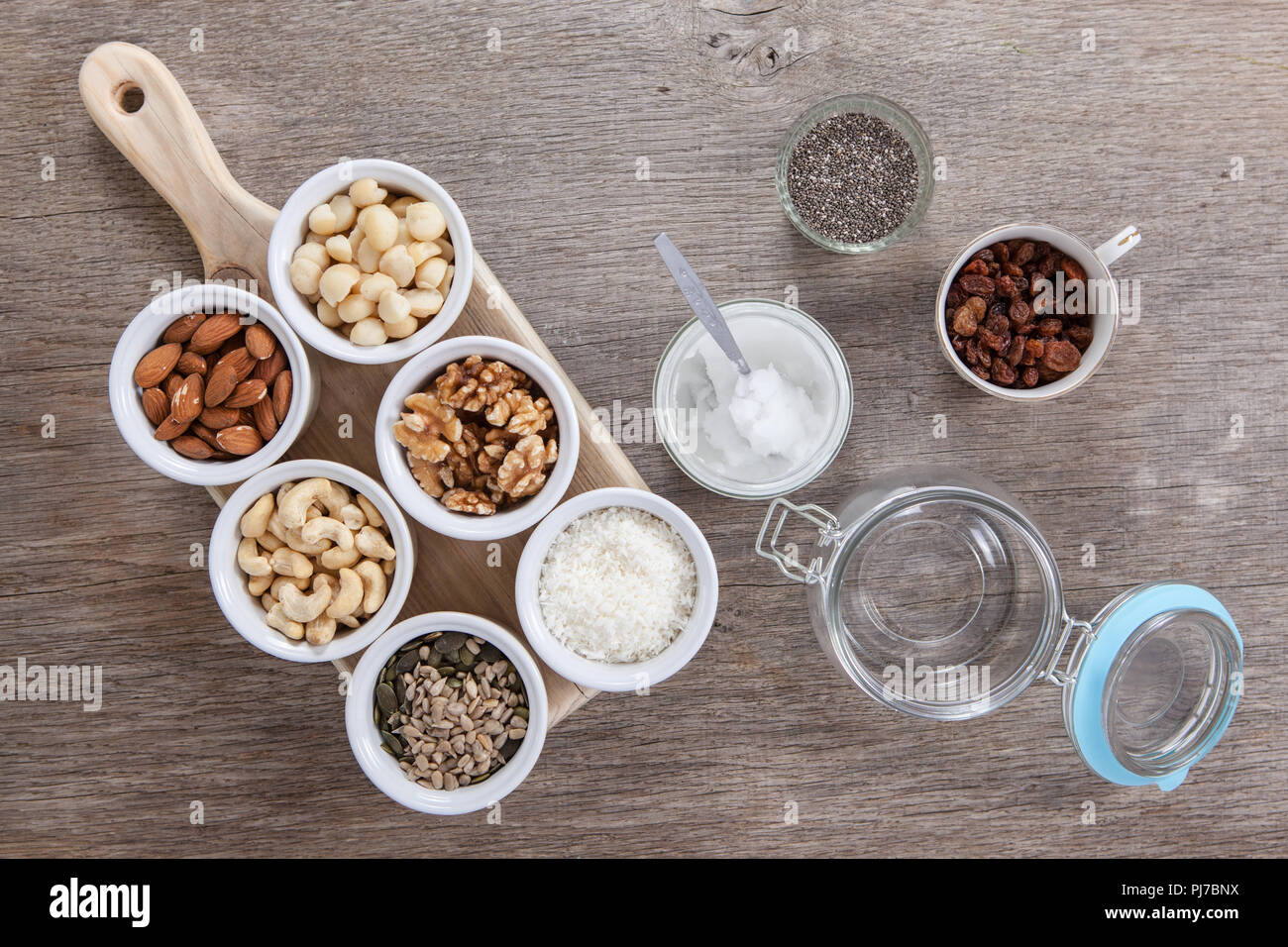 Zutaten für Getreide frei paleo Müsli: gemischte Nüsse, Samen, Rosinen, Kokosflocken, Chia und Kokosöl Stockfoto