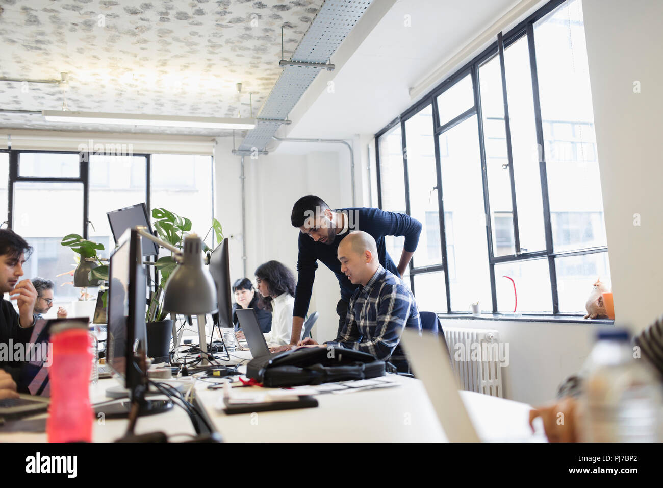 Unternehmer bei der Laptop im Großraumbüro arbeiten Stockfoto